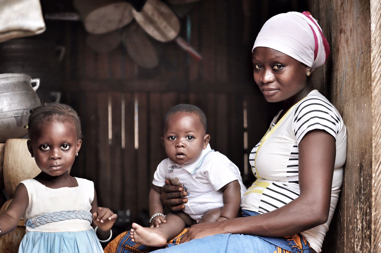 A tender moment of a mother with her children in a cozy, rustic environment.